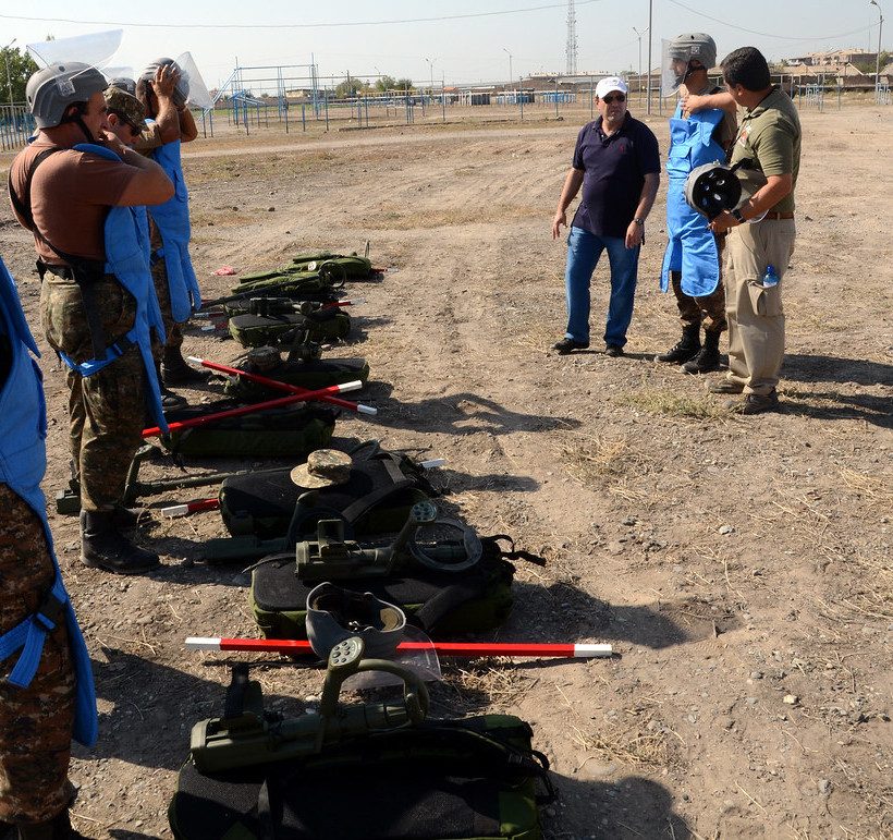 Demining team with protective vests and equipment during field training