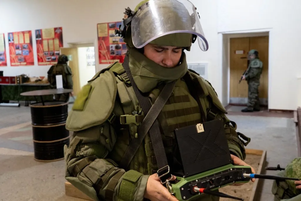 EOD specialist in a bomb suit during an indoor demining exercise