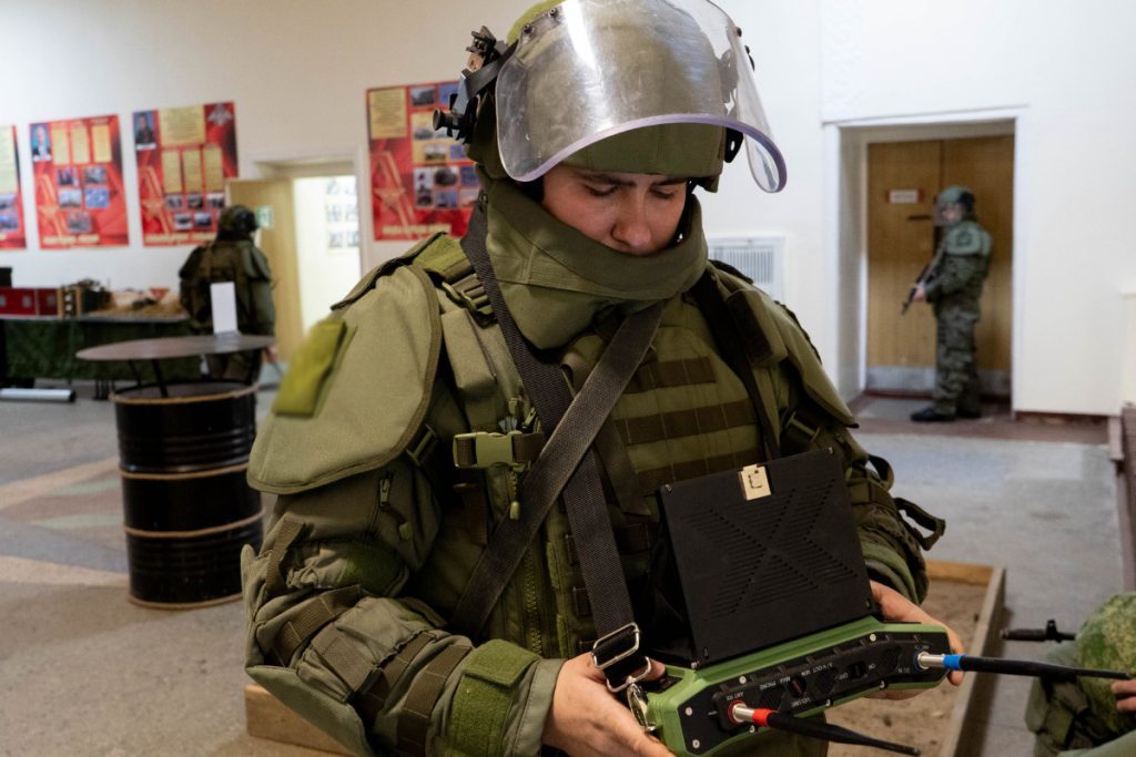 EOD specialist in a bomb suit during an indoor demining exercise